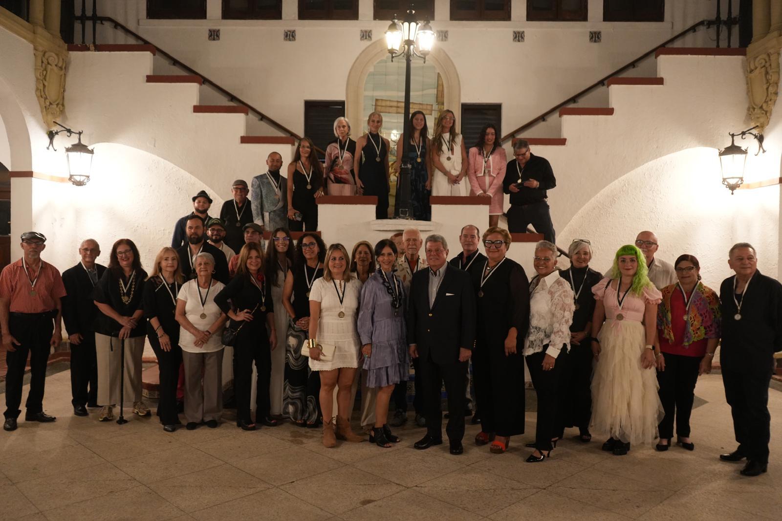 La mayoría de los 36 artistas participantes, tras recibir una medalla conmemorativa durante la inauguración de la exposición colectiva en Casa de España.